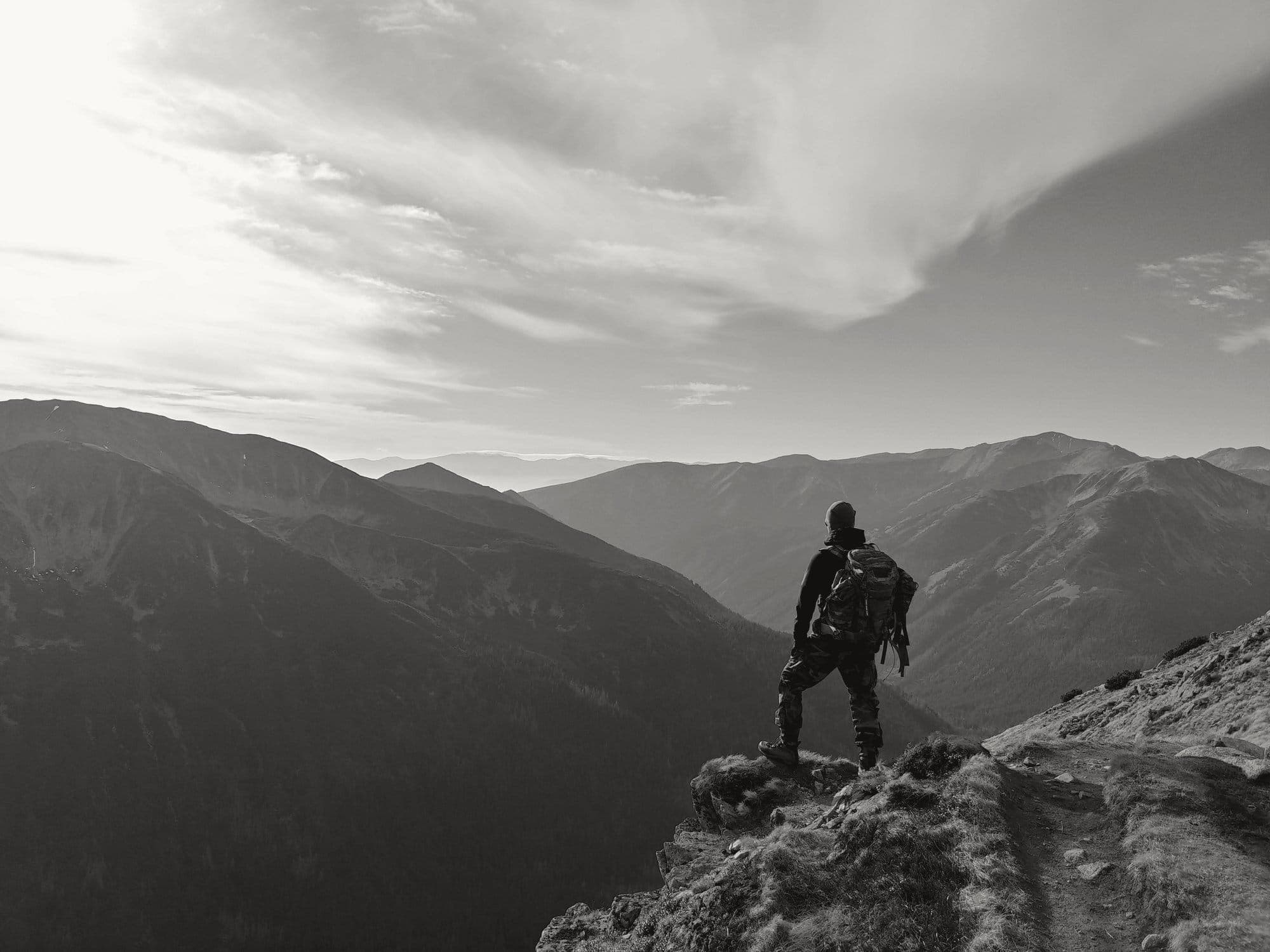 A walker on a summit looking out over the mountains